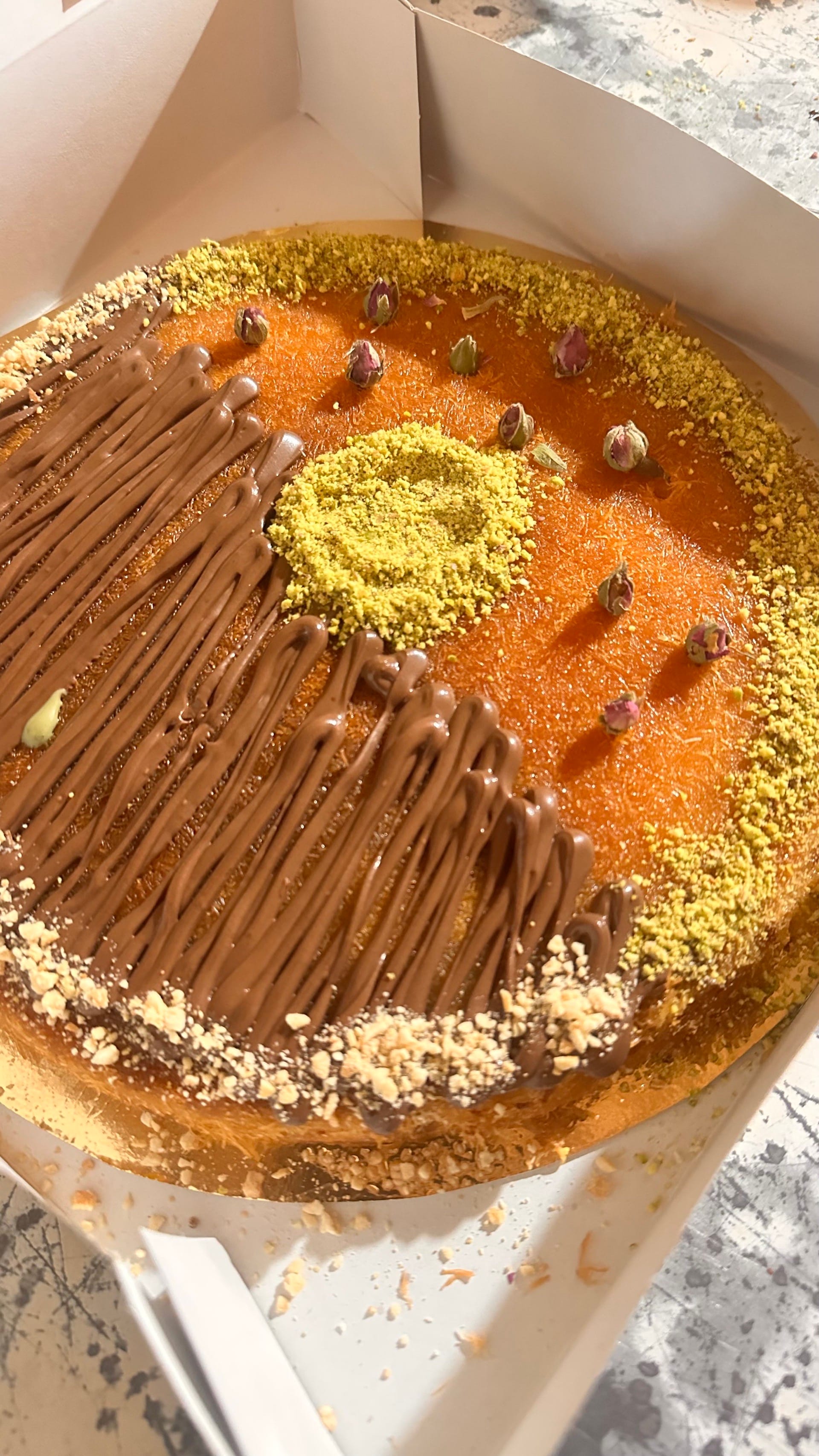 Portion individuelle de kunafa avec un filet de sirop coulant, un délice pour les yeux et les papilles.