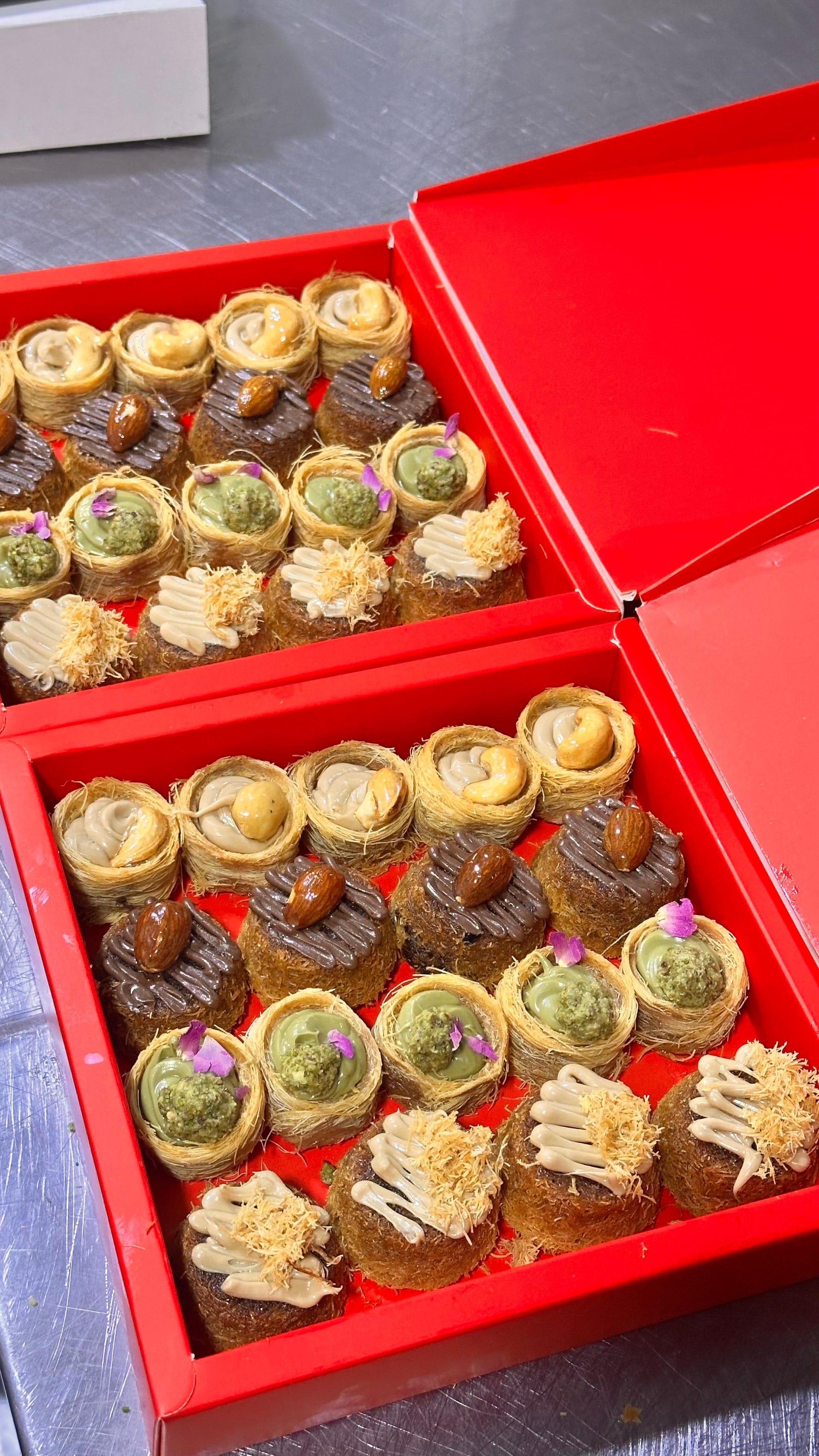 Assortiment de kunafa baklava variés, présentant différentes tailles et garnitures, parfait pour partager.